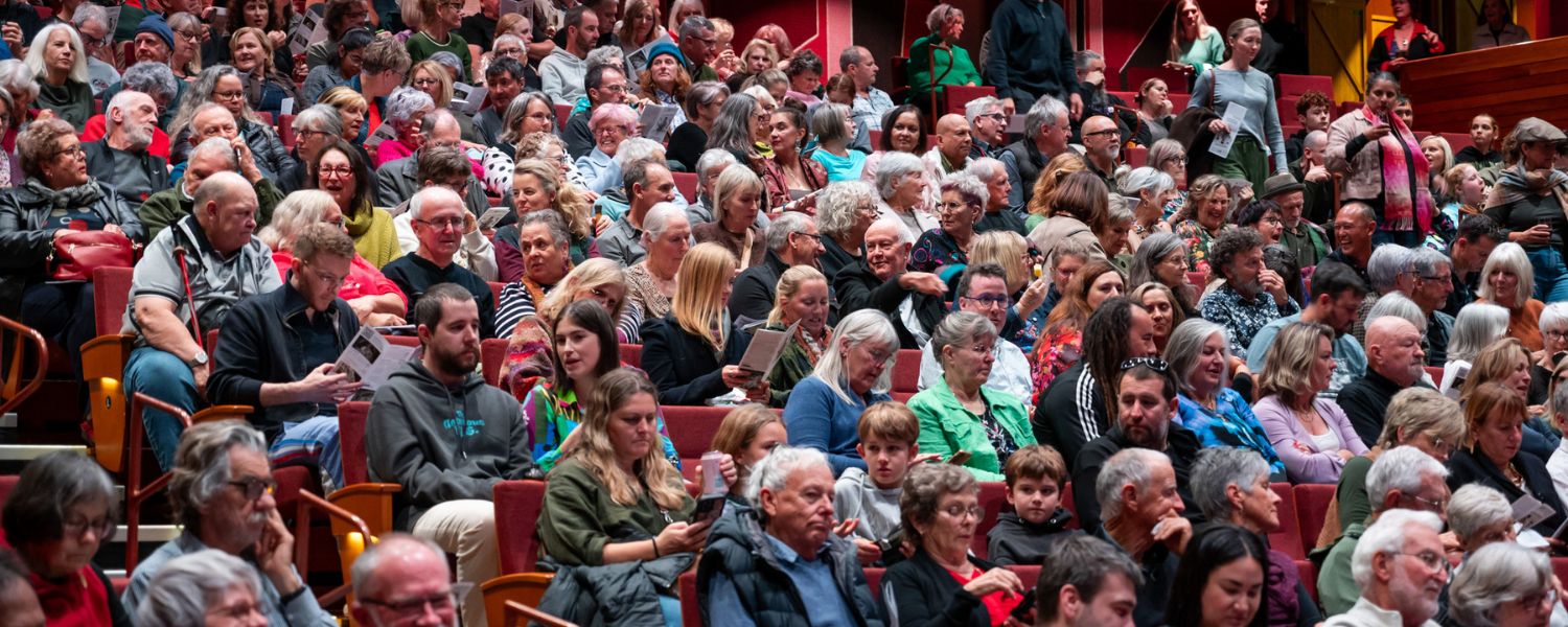 Audience filling the Addison Theatre auditorium.